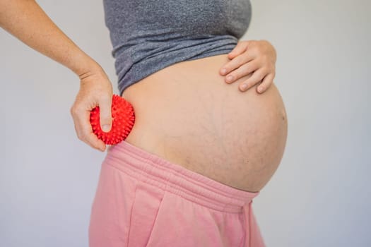 Self-massage with a massager for a pregnant woman.