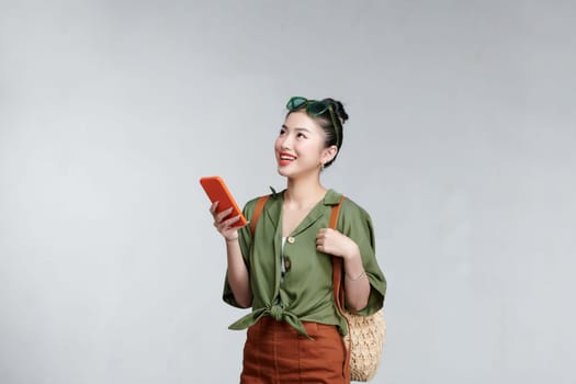 Happy young Asian tourist woman using smartphone application going to travel on holidays
