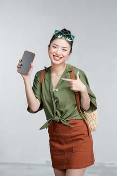 Beautiful woman showing smartphone and pointing something in travel summer trip in vacation