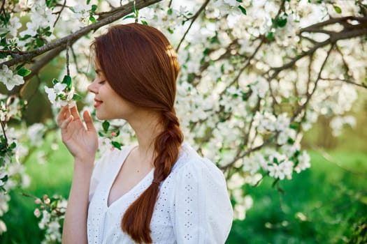 woman with flowers. gorgeous model in the spring garden. the girl near the tree in the spring. the concept of spring. young orchard. High quality photo