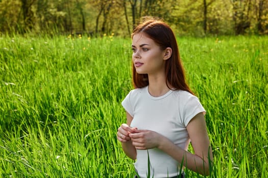 portrait of a woman sitting in tall grass and lit by the sun from the back. High quality photo