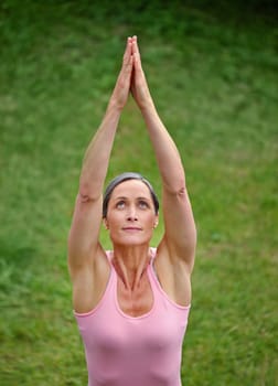 Yoga in the fresh air. an attractive mature woman doing yoga outdoors