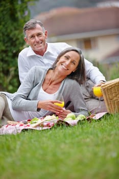 They make time for romance in their marriage. Portrait of a loving mature couple having a picnic on the grass