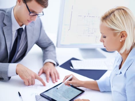 Using the latest technology for accuracy and efficiency. a male and female architect working on a digtial tablet