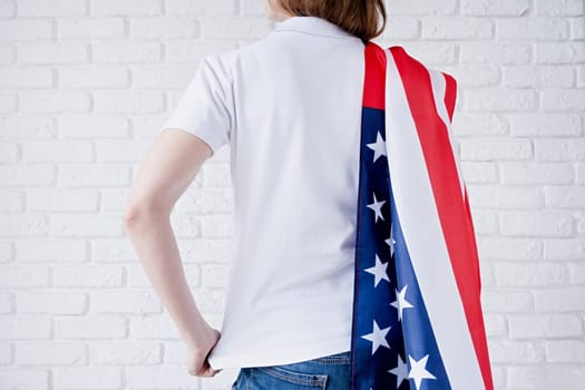 White polo shirt on woman over USA flag background, mockup design. Indoor studio shot