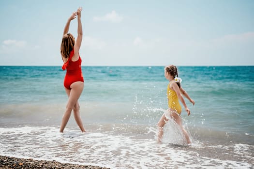 Happy loving family mother and daughter having fun together on the beach. Mum playing with her kid in holiday vacation next to the ocean - Family lifestyle and love concept.