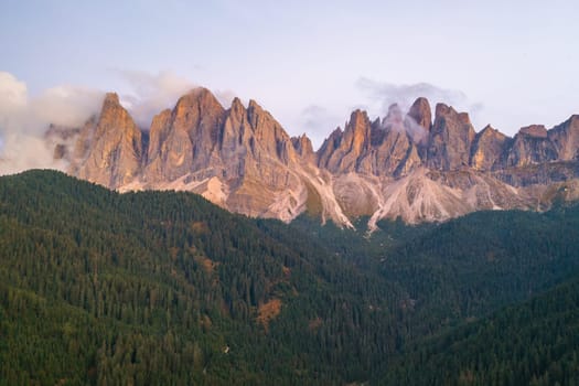 The beautiful massif of the Dolomites of Odle or Geisler group covered with clouds at sunset.