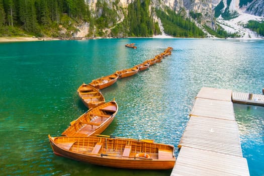Stunning view of Lake Braies with wooden boats and Dolomites, Italy.