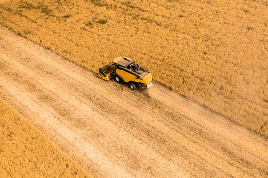 Top view of a combine harvester harvesting wheat from a field.