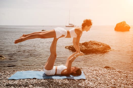 Woman sea yoga. Back view of free calm happy satisfied woman with long hair standing on top rock with yoga position against of sky by the sea. Healthy lifestyle outdoors in nature, fitness concept.