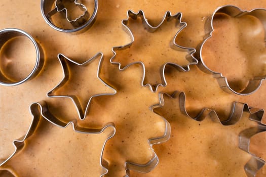 Cutting out cookies with metal mold from the shortcrust pastry. A metal forms in the form of snowflakes for making gingerbread for Christmas.