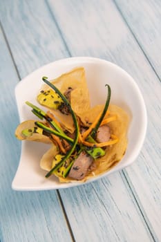 Brick with marinated red tuna, soy sauce, nuoc mam, ginger, black sesame, avocado, carrot slices, courgette. High quality photo