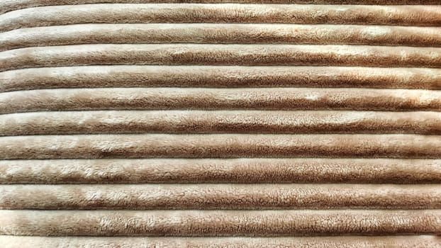 Striped Abstrack background and texture. Closeup photo of soft fluffy sleeping beige a blanket or plaid. Partial focus