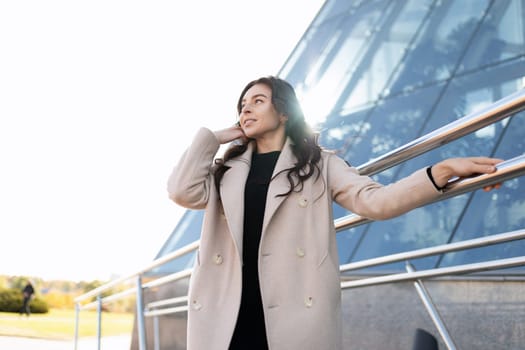 portrait of a successful young business woman against the backdrop of an office modern building.