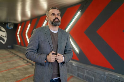 brutal male businessman in a business suit in the underground parking.