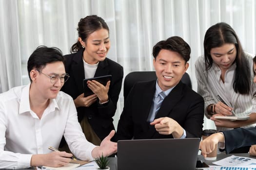 Harmony in office concept as business people analyzing dashboard paper together in workplace. Young colleagues give ideas at manager desk for discussion or strategy planning about project.