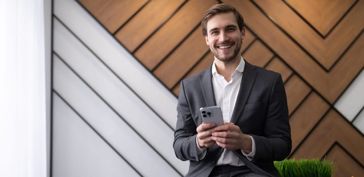 male head in a business suit with a phone in the office.