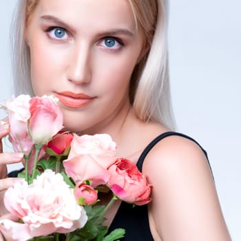 Closeup young personable woman with natural makeup and healthy soft skin holding rose for beauty care advertising in isolated background. Beautiful pretty model girl with flower concept.