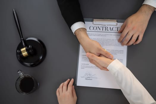 Top view lawyer or attorneys colleagues handshake after successful legal discussing on contract agreement for lawsuit to advocate resolves dispute in court ensuring trustworthy partner. Equilibrium