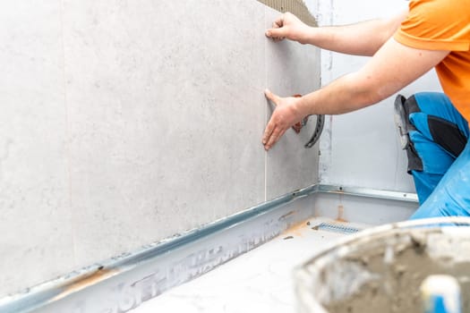 craftsman tiling the room with large format tiling. High quality photo