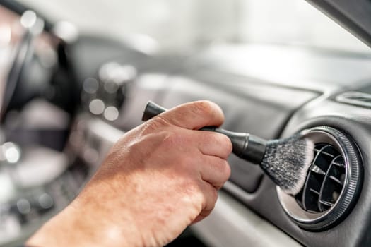 cleaning the interior of a luxury car with a brush. High quality photo