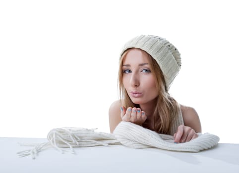 Lovely girl in knitted hat sending air kiss, isolated on white background