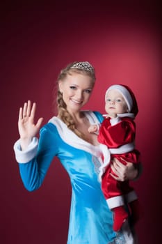 Happy mom-Snow Maiden holds baby-Santa Claus, on pink background