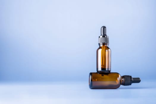 Two glass brown bottles with a pipette for a cosmetic product. Natural cosmetics for face and body skin care. Selective focus. Place for text.