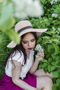 A fashionable girl with dark hair, a spring portrait in lilac tones in summer. Bright professional makeup