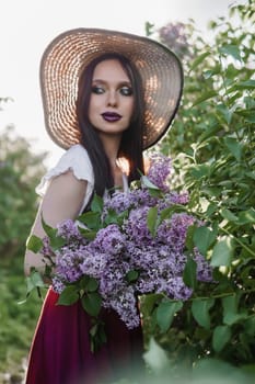 A fashionable girl with dark hair, a spring portrait in lilac tones in summer. Bright professional makeup