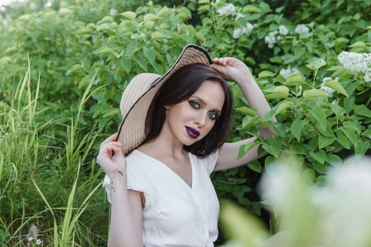 A fashionable girl with dark hair, a spring portrait in lilac tones in summer. Bright professional makeup