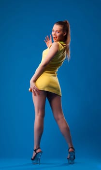 Cheerful young girl posing with bright makeup, on blue background