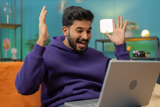 Oh my God Wow. Surprised indian man using laptop computer, receive good news message, shocked by sudden victory, celebrate lottery jackpot win purchases online shopping at home. Lifestyle technologies