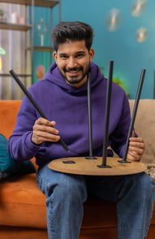 Happy indian man finishing assembling furniture at home. Successful table desk collect repair fixing. Hindu guy after moving into new apartment. Advertisement of a furniture store. Mortgage, lifestyle