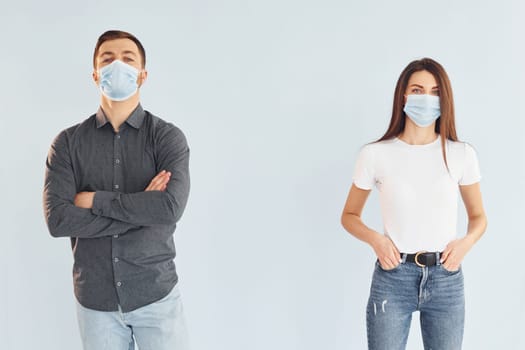 Man and woman standing indoors in the studio against white background.