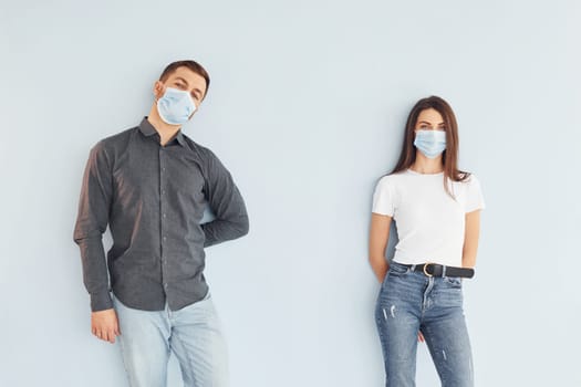 Man and woman standing indoors in the studio against white background.