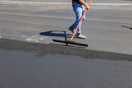 Laying asphalt with working men shoveling black gravel for on road