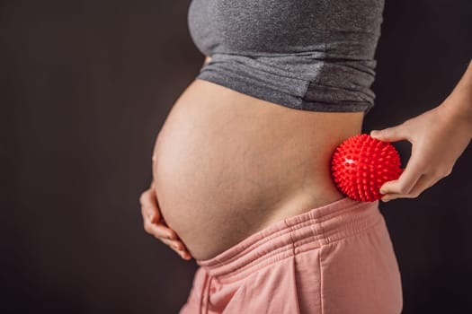 Self-massage with a massager for a pregnant woman.