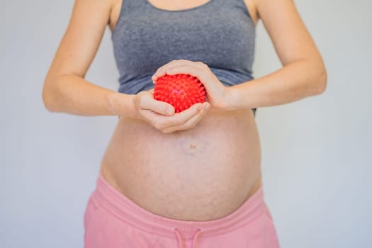 Self-massage with a massager for a pregnant woman.