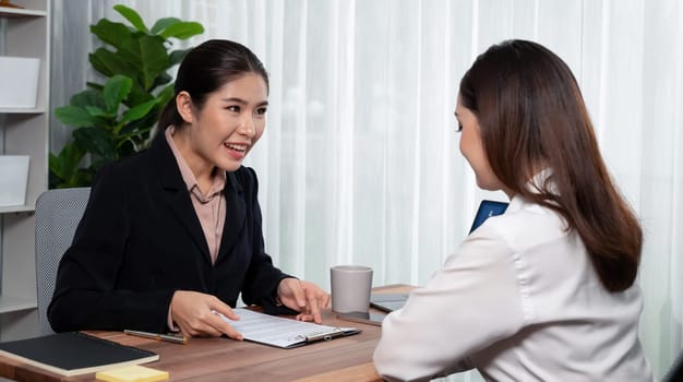 Business deal meeting, young businesswomen carefully reviewing terms and condition of contract agreement papers in office. Corporate lawyer give consultation on contract deal. Enthusiastic