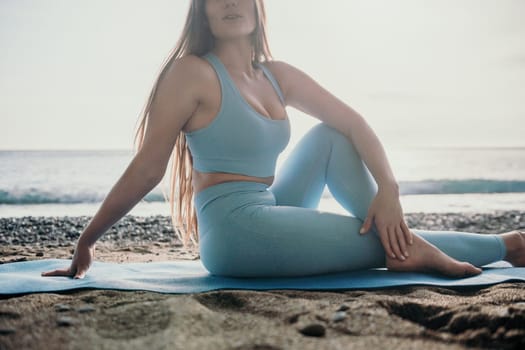 Middle aged well looking woman with black hair doing Pilates with the ring on the yoga mat near the sea on the pebble beach. Female fitness yoga concept. Healthy lifestyle, harmony and meditation.