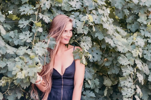 Woman at autumn winery. Portrait of happy woman holding glass of wine and enjoying in vineyard. Elegant young lady in hat toasting with wineglass smiling cheerfully enjoying her stay at vineyard