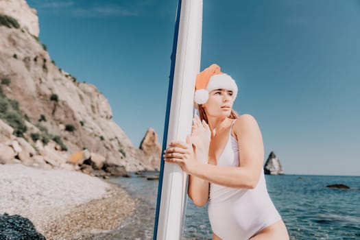 Close up shot of happy young caucasian woman looking at camera and smiling. Cute woman portrait in bikini posing on a volcanic rock high above the sea