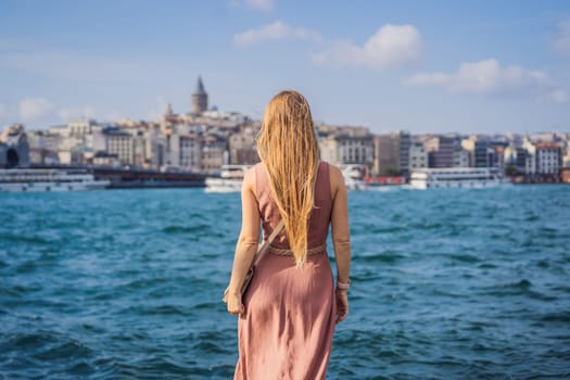 Portrait of beautiful woman tourist with view of Galata tower in Beyoglu, Istanbul, Turkey. Turkiye.
