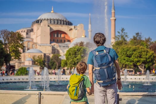 Father and son Tourists enjoy beautiful view on Hagia Sophia Cathedral, famous islamic Landmark mosque, Travel to Istanbul, Turkey. Traveling with kids concept. Sunny day architecture and Hagia Sophia Museum, in Eminonu, istanbul, Turkey. Turkiye.