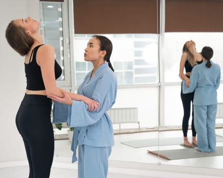 Caucasian woman stands on sadhu boards with therapist support