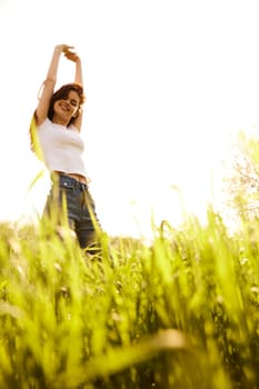 a woman on a bright sunny summer day standing in a yellow field. High quality photo