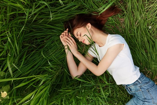 serene, woman lies in green tall grass in casual clothes. High quality photo