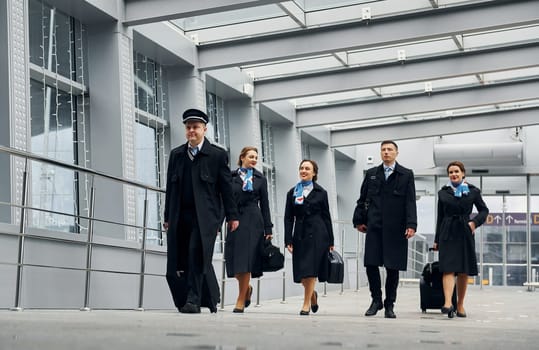 In uniform. Airplane crew in uniform is going to the work together.