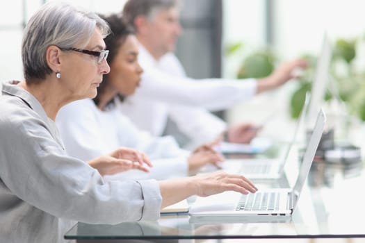 Elderly call center employee at the computer.